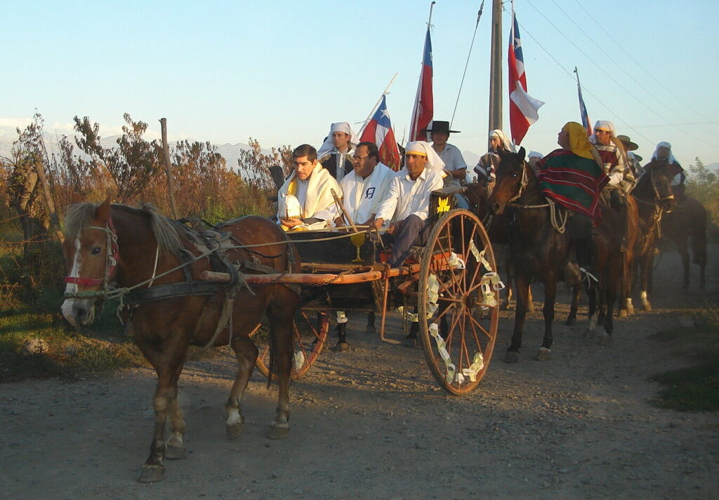 Cuasimodistas a caballo vestidos con camisa blanca y esclavina durante la Fiesta de Cuasimodo en Chile