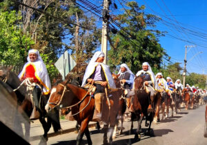 Cuasimodista vestido con camisa blanca y esclavina tradicional de colores